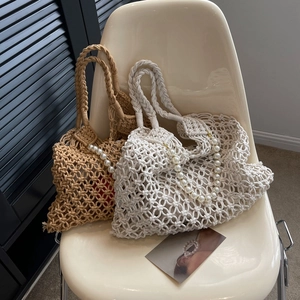 Detail of hand-woven hollow bags with decorative pearl chains in cream and khaki colors