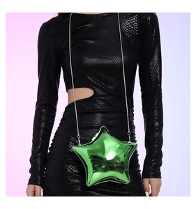 Close-up of star-shaped emerald green acrylic bag with silver chain on black dress