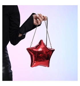 Detail of red star-shaped acrylic evening bag with metallic finish and silver chain strap