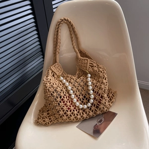 Close-up of woven mesh beach bag with white pearl chain and thick braided handles