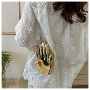 Mirror gold hand-shaped acrylic clutch bag with metallic finish and gold chain detail