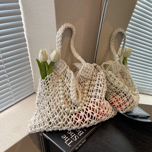 Detail of macrame mesh beach bag with large faux pearl chain and spiral handles