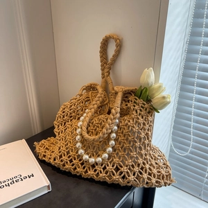 Detail of hollow mesh woven bag with luxury faux pearl handle for beach vacations