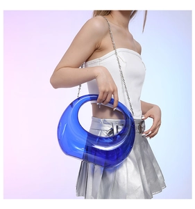Close-up of translucent blue acrylic crescent bag with silver chain strap and hollow design