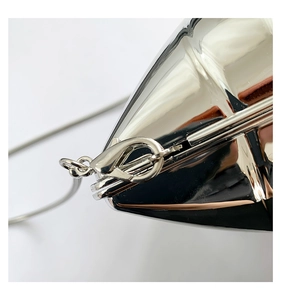 Detail of silver heart-shaped mirror acrylic bag with polished metal snake chain strap