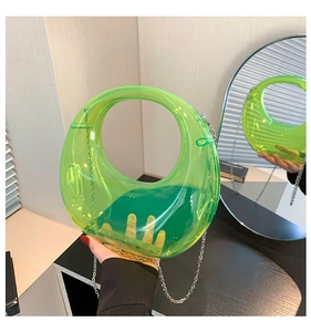 Detail of neon green translucent acrylic crescent bag with silver metal chain strap