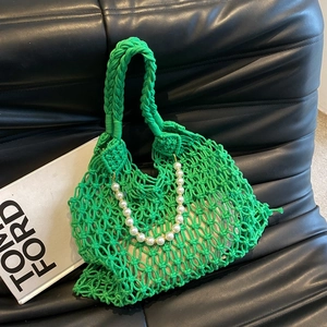 Detail of green woven hollow mesh beach bag with pearl chain and beige inner lining