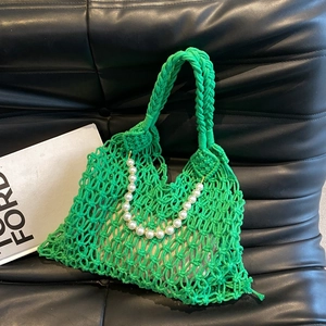 Detail of green macramé beach bag with pearl handle and woven shoulder strap