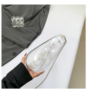 Detail view of crescent acrylic evening bag with gold interior accents and chain strap
