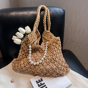 Detail of khaki mesh tote bag with a white faux pearl chain and woven handles