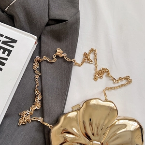 Detailed view of flower-shaped gold metal evening bag with fine chain and metallic finish