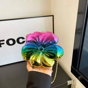 Detailed view of rainbow gradient flower clutch with metallic finish and gold chain strap