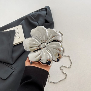 Detail of flower shaped evening bag in silver metallic finish with elegant chain strap