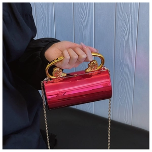 Details der roten runden Acryl-Clutch mit goldenem Löwengriff und Kettenriemen