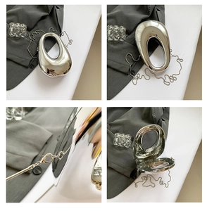 Detalle de bolso plateado cromado irregular con cadena de metal y efecto espejo