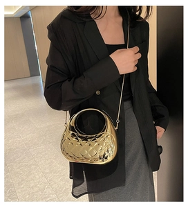 Detail of quilted metallic gold cloud shell clutch with round handle and chain strap