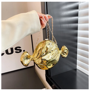 Detail of candy-shaped golden dinner clutch bag with elegant metallic chain strap