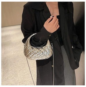 Detail of silver metallic quilted crescent bag with mirror finish and slim chain strap