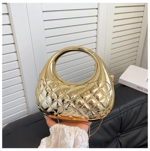 Close-up of golden metallic clutch featuring quilted rhombic texture and round handle