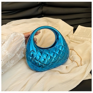 Macro detail of electric blue quilted acrylic clutch bag with golden chain strap