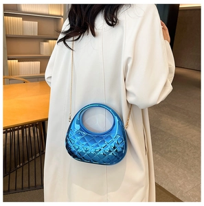 Detail of electric blue metallic shell bag with quilted rhombus pattern and chain strap