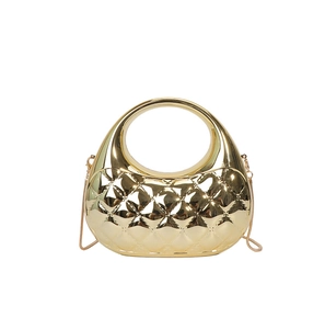 Detail of glossy gold metallic evening clutch featuring quilted diamond patterns and chain