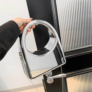Close-up of silver mirror acrylic evening bag with oversized round handle and chain