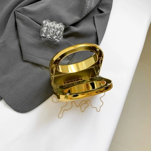Detail view of gold electroplated acrylic evening clutch with metal ring handle and chain