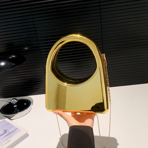 Detailed view of the gold mirror acrylic evening bag with geometric round handle and chain