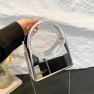 Detail of silver mirror evening bag with circular cutout handle and chain strap