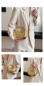 Detail der gold gesteppten Acryl-Clutch mit Metallringgriff und Kettenriemen