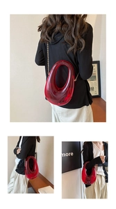 Detail of red acrylic evening bag with hollow oval handle and gold chain strap