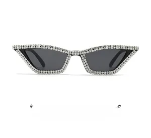 Détail de lunettes de soleil œil de chat avec strass sur monture noire et verres gris