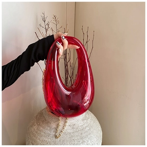 Detail of red translucent acrylic donut bag with elegant gold chain strap