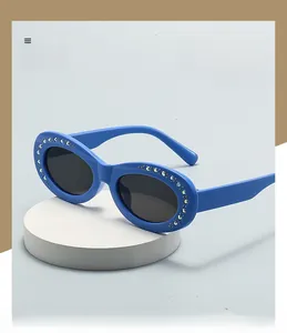 Macro shot of oval frame sunglasses with colorful rhinestones on a white pedestal