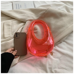 Detailed macro view of a mini acrylic evening bag next to a smartphone for size reference