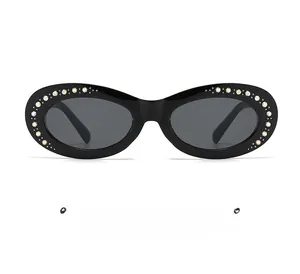 Detail of oval black sunglasses featuring luxury gradient rhinestones on the frame edge