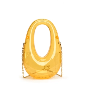 Detailed view of yellow translucent acrylic clutch bag with integrated handle and gold chain