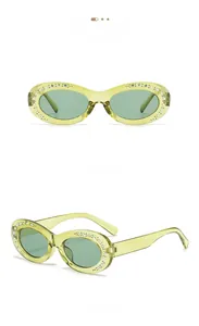 Detail view of oval translucent green sunglasses with colorful rhinestone embellishments