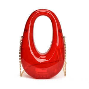 Detailed view of an oval red transparent acrylic clutch bag with built-in handle and gold chain