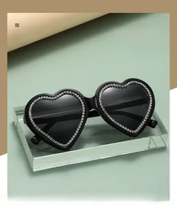 Detail of black heart sunglasses with fine white rhinestones on crystal block stand