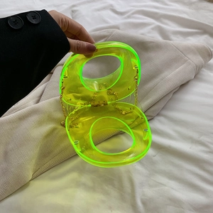Detail of neon green acrylic clutch featuring a unique double-circle figure-eight design