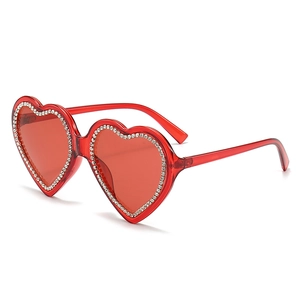 Fashionable red heart shaped sunglasses with crystal rhinestones on white background