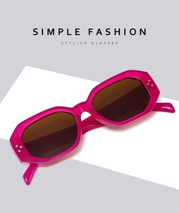 Détail de lunettes de soleil géométriques rose fuchsia avec rivets et verres bruns