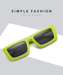 Detail of neon green rectangular sunglasses with dark lenses and simple street fashion design