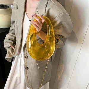 Modern amber acrylic clutch with curved cutout design and gold chain strap for women