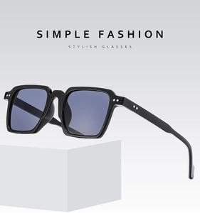 Detail view of square black frame sunglasses with blue lenses and silver rivets