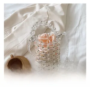 Detail of acrylic pearl beaded bucket bag with gold studs and satin drawstring liner
