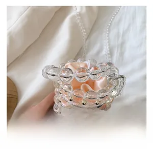Handheld detail of acrylic pearl beaded bucket bag with pink satin drawstring liner