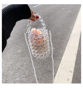 Detail of handmade clear acrylic pearl bucket bag with a satin drawstring lining